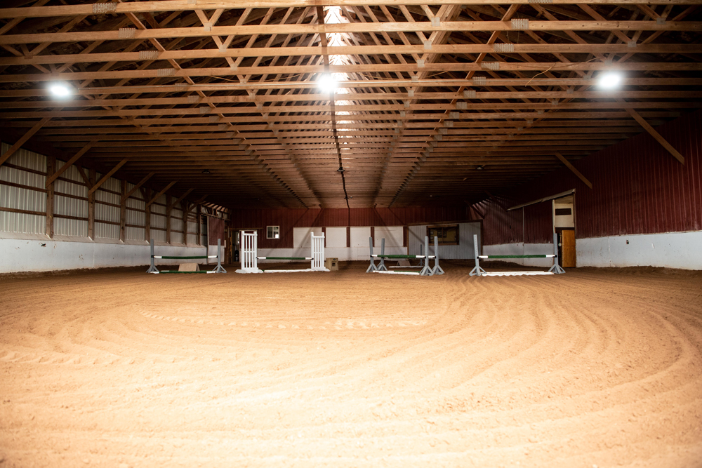 Indoor arena with sand footing and jumps set