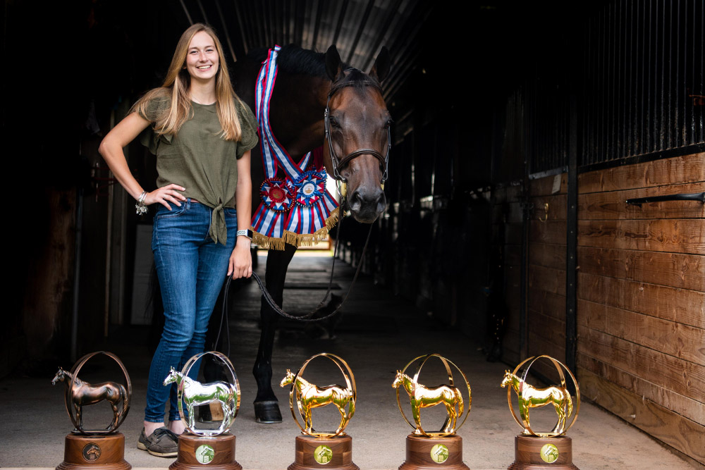 Maddy Keyes poses with Classic Circle and their AQHYA World Championship globes