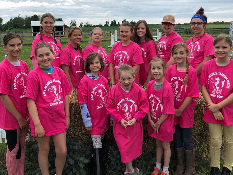 summer10 Campers wearing matching t-shirts pose in outdoor arena