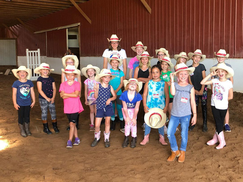 summer11 Campers wearing cowboy hats pose in indoor arena