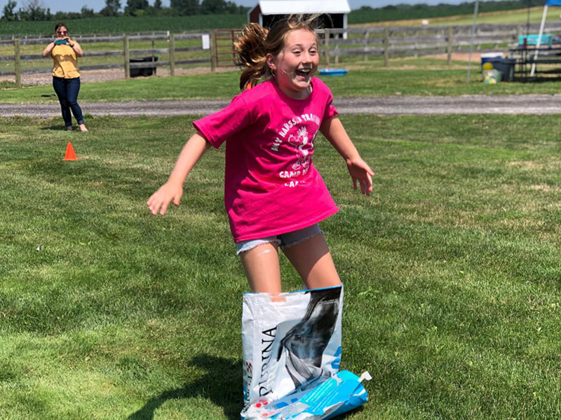 summer8 Camper competes in sack race using empty feed bag